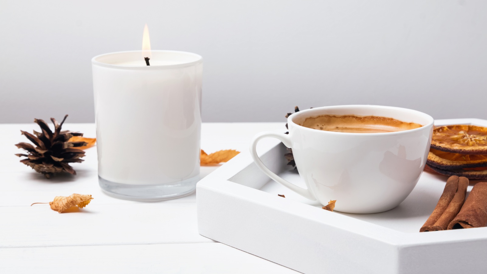 candle flame and a ceramic cup of coffee display