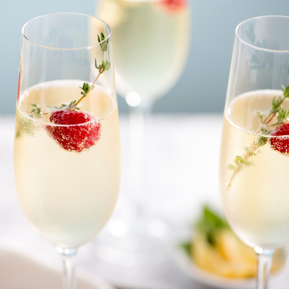 Glasses with champagne and a single berry in the glass