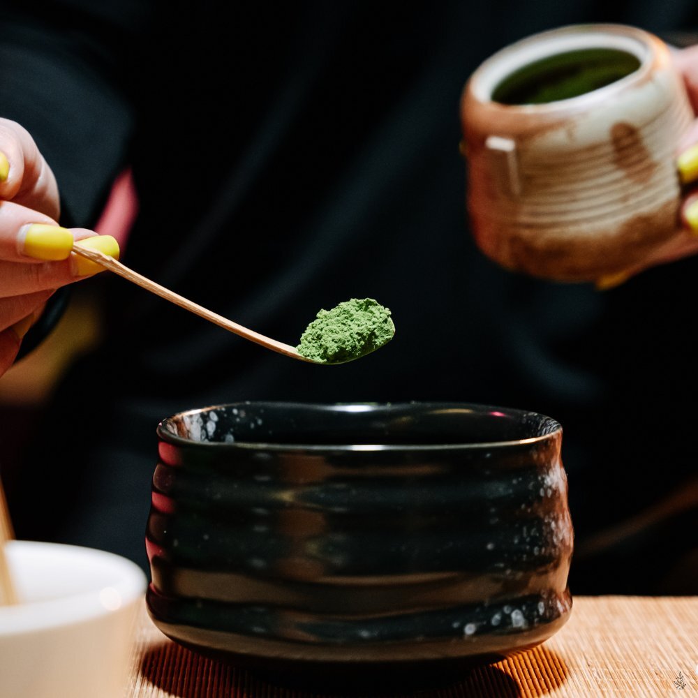 Adding a small amount of warm water to matcha (placeholder image)