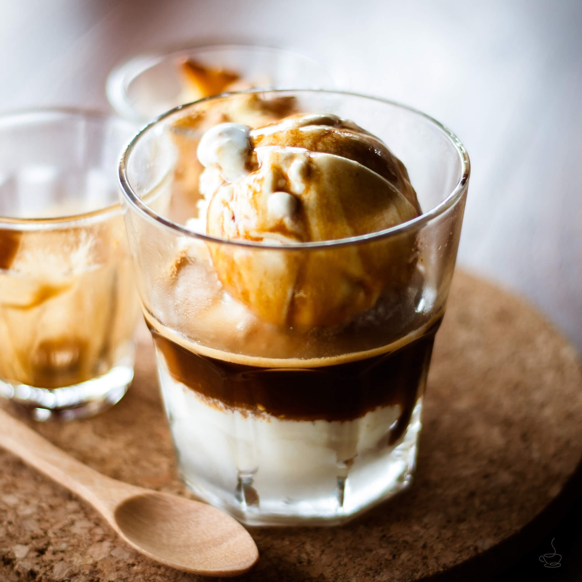 Affogato dessert with espresso poured over vanilla ice cream in a small glass