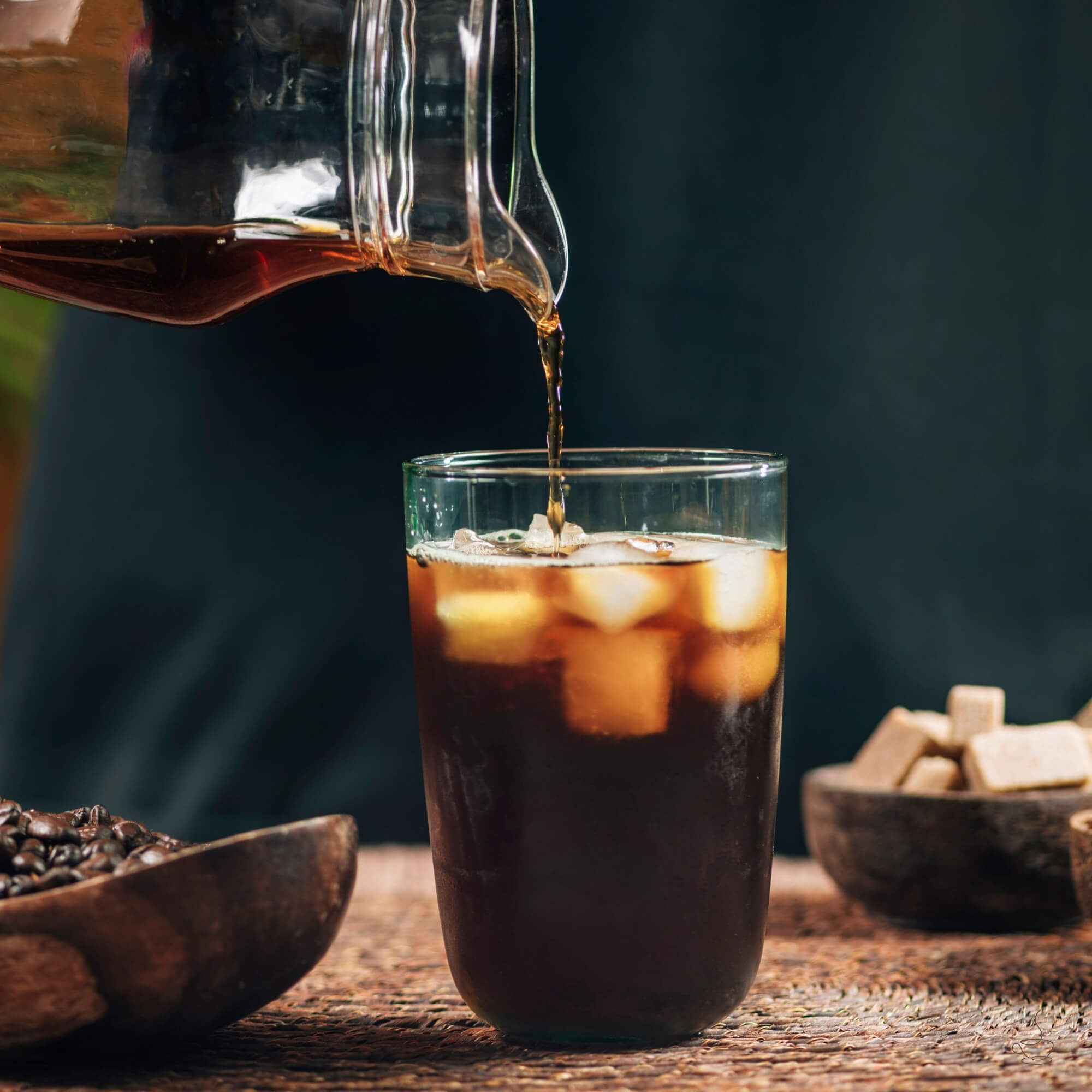 Jar of cold brew concentrate next to a glass of iced coffee