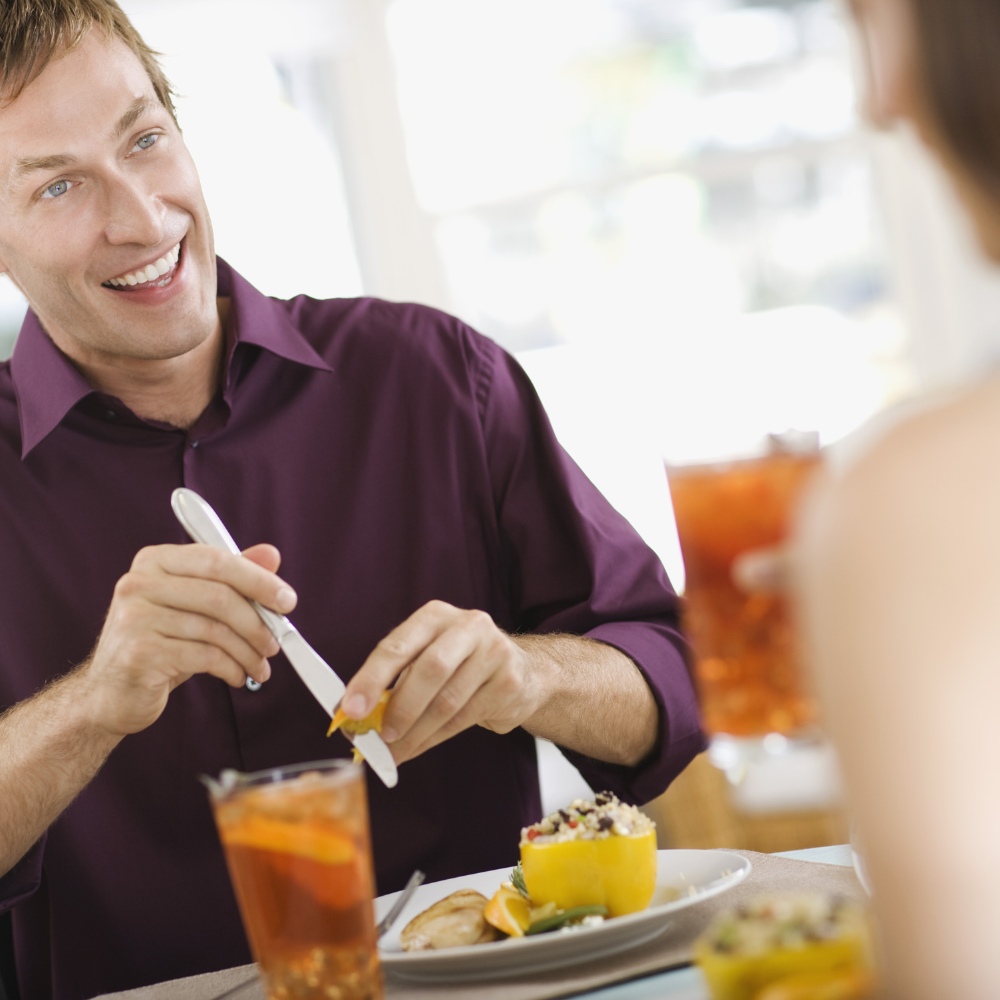 Couple drinking Rooibos iced tea with food at a table