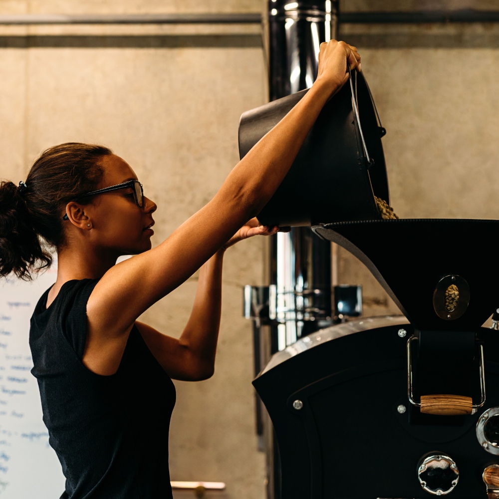 Roaster loading a drum – small-batch roasting at Coo Coos