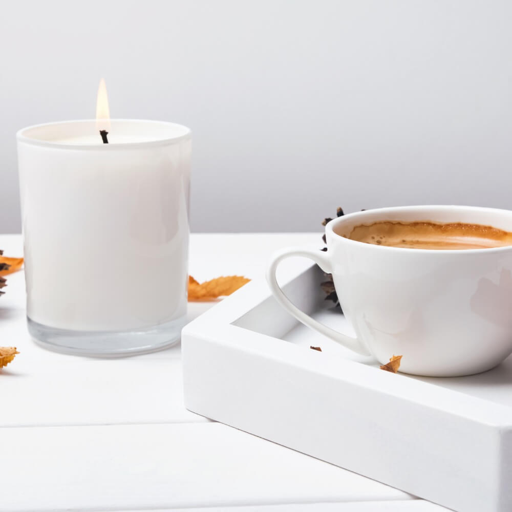 Jar candle and coffee cup on a cozy tray