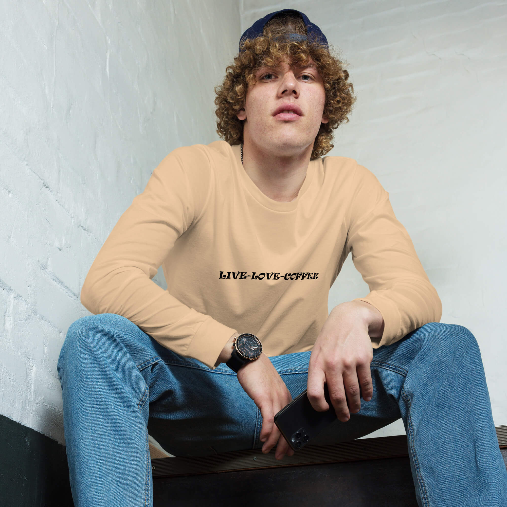 Live-Love-Coffee long sleeve tee shirt in a sand dune color. Male model holding cell phone.