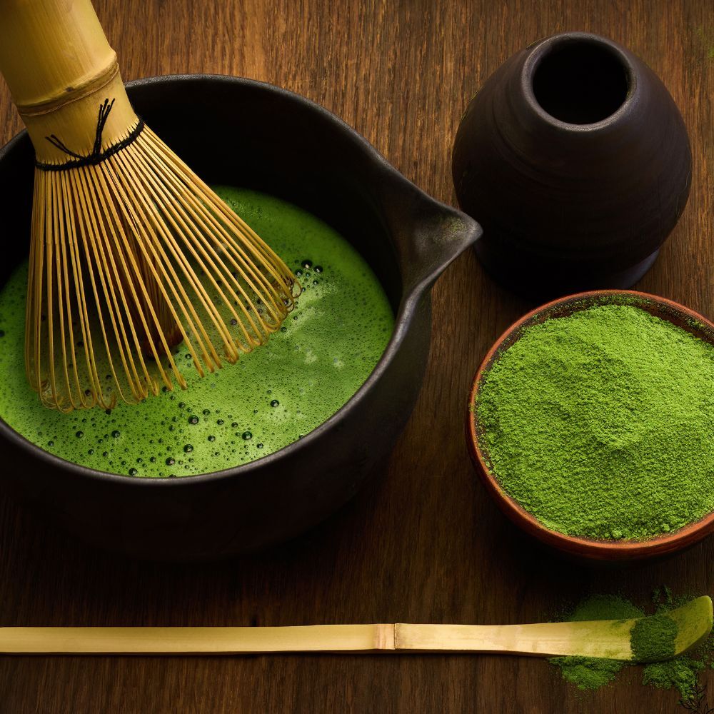 Matcha powder and whisked matcha bowl