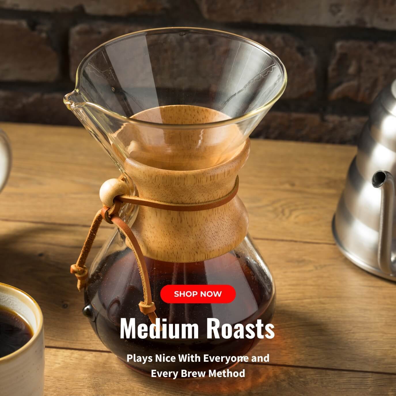 Freshly brewed medium roast coffee in a Chemex pour-over on a wood table with kettle, representing balanced and versatile brews from Coo Coo’s Coffee