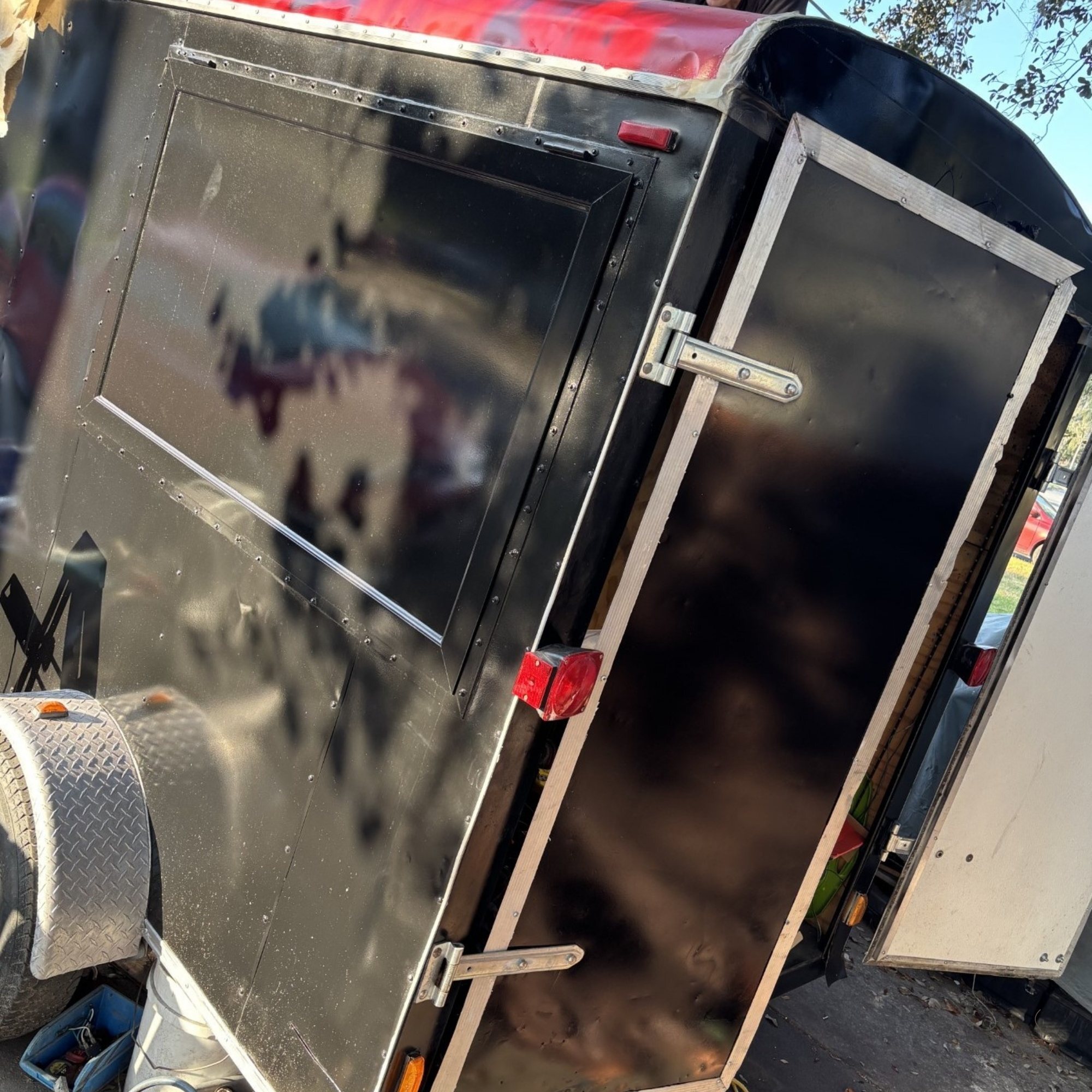 Coffee trailer build in progress with tools, plans and a future service window