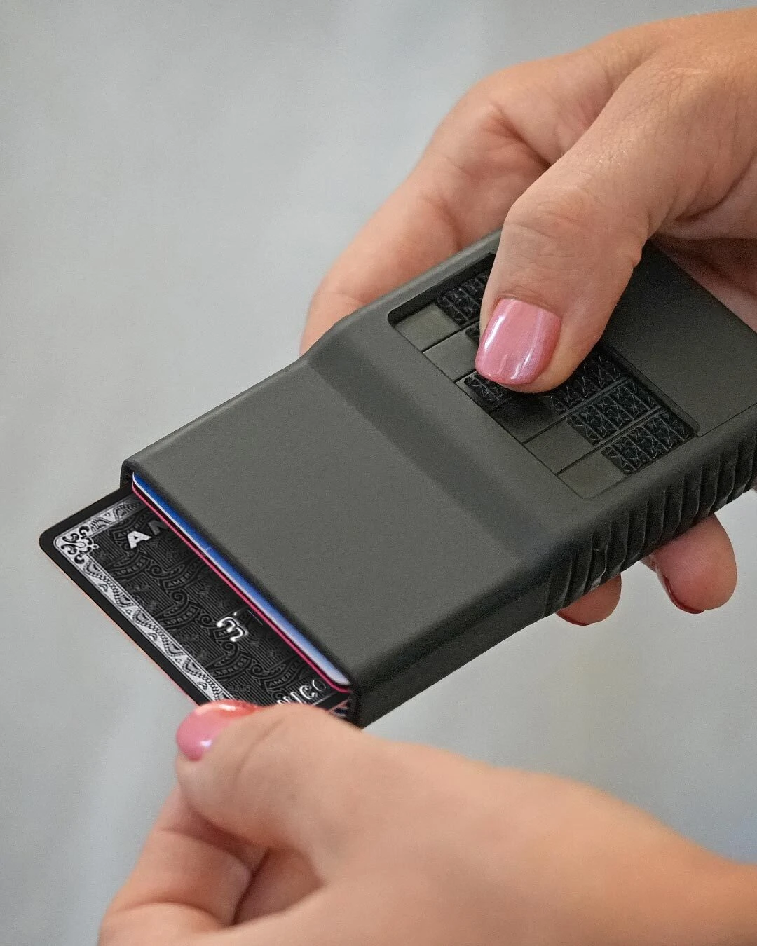 Female hand pressing a Black Satin selector to get one exact card