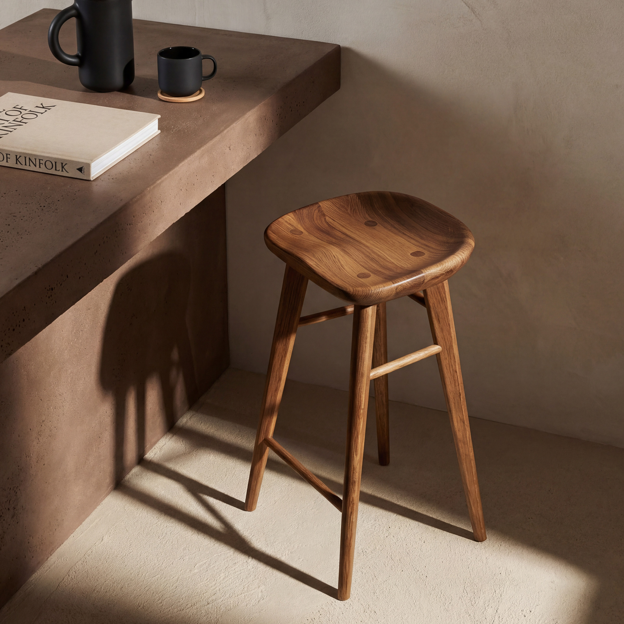 a wooden desk with a book and cups on it