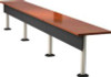 Surface mounted posts supporting a long rectangular table with a wood top and black modesty panel.