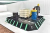 Man pouring - Worker pouring liquid into a drum inside the containment berm.