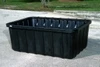 An empty black containment sump positioned on a paved surface outdoors.