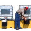 Worker setting up containers on the Twin IBC Spill Pallet, No Drain, demonstrating its user-friendly design and industrial-grade performance.