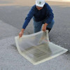 Worker placing a clear 18” x 18” drain seal over a drain, showcasing its flexibility and secure coverage for spill control.