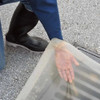 Close-up of a clear drain seal being adjusted to form a tight seal over a drain, ensuring spill prevention and safety compliance.