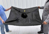Black curb model drain guard being held up by two workers in a factory warehouse.