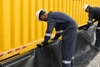 Worker fastening the liner to the containment wall with precision.