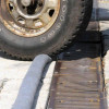 A close-up image of a Trench Filter Boom being driven over by a tire, showcasing its durable and traffic-friendly design.