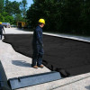 Worker adjusting modular berm walls with a 2' x 2' corner section to ensure secure and seamless installation.
