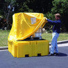 IBC pull over cover being placed on a IBC spill pallet, by a man standing on outside, for protection against weather.