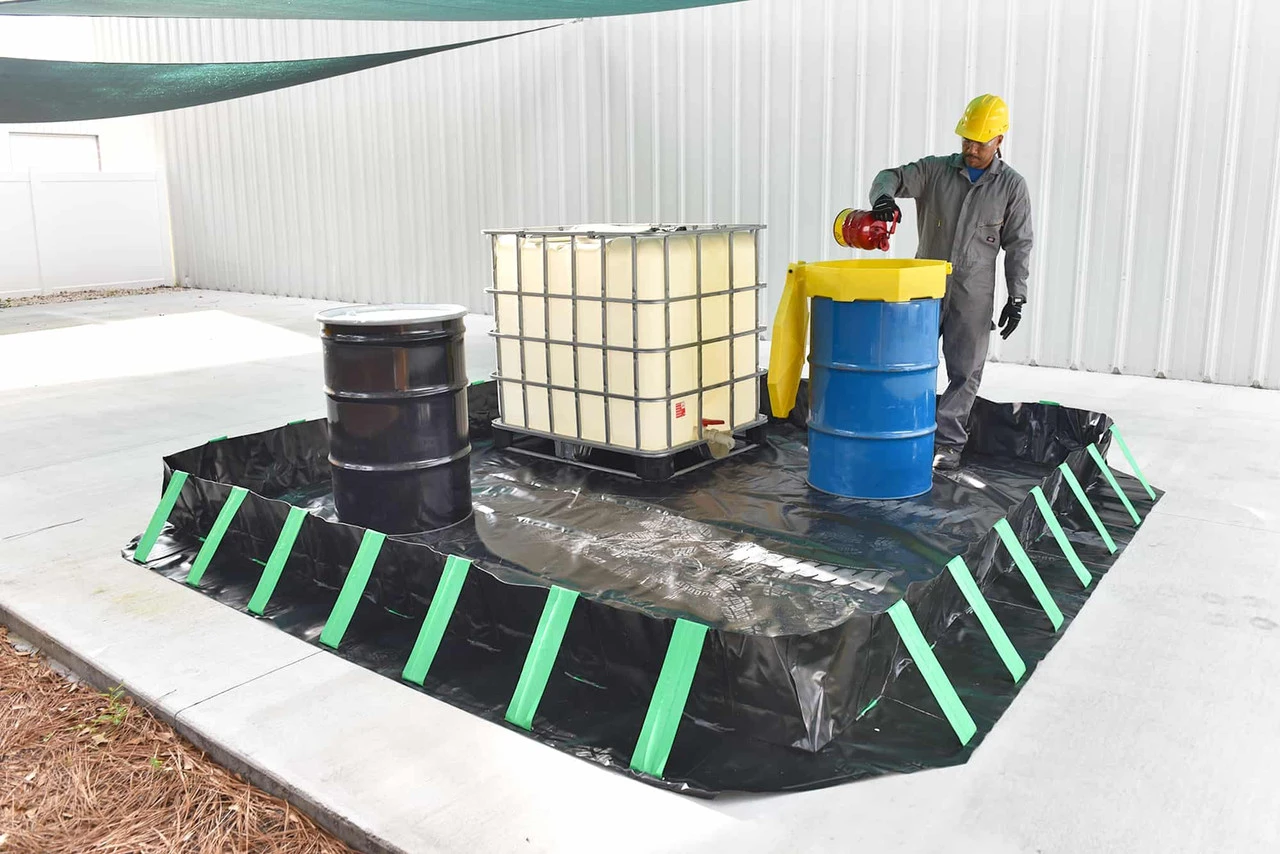 Man pouring - Worker pouring liquid into a drum inside the containment berm.