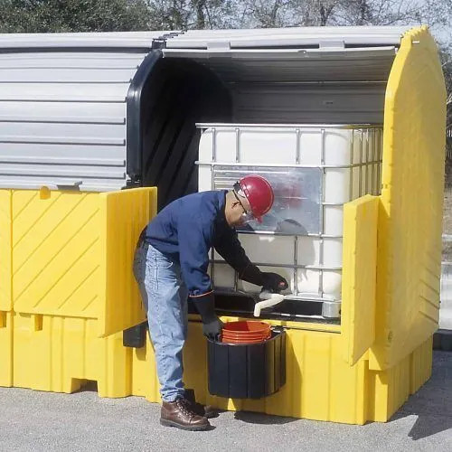 Worker accessing containers inside the Twin IBC Hard Top, With Drain, showcasing its secure and weatherproof design for industrial spill containment.