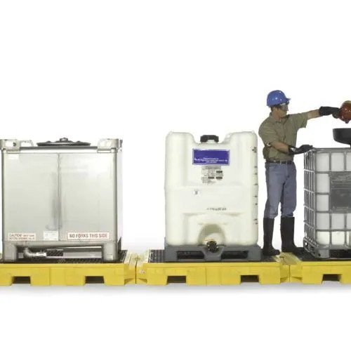 Industrial water tanks being inspected for quality by maintenance worker.
