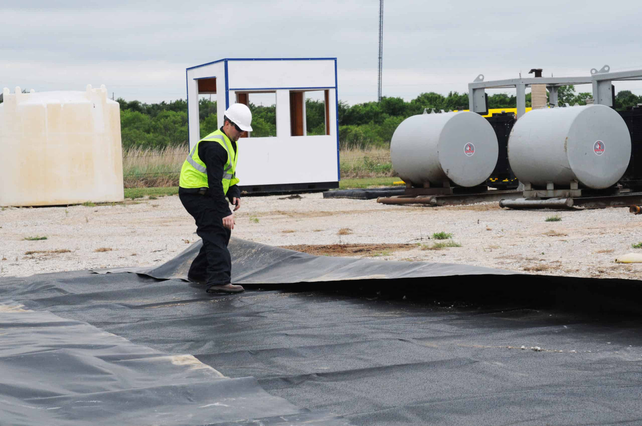Containment liner installed inside a berm around storage tanks