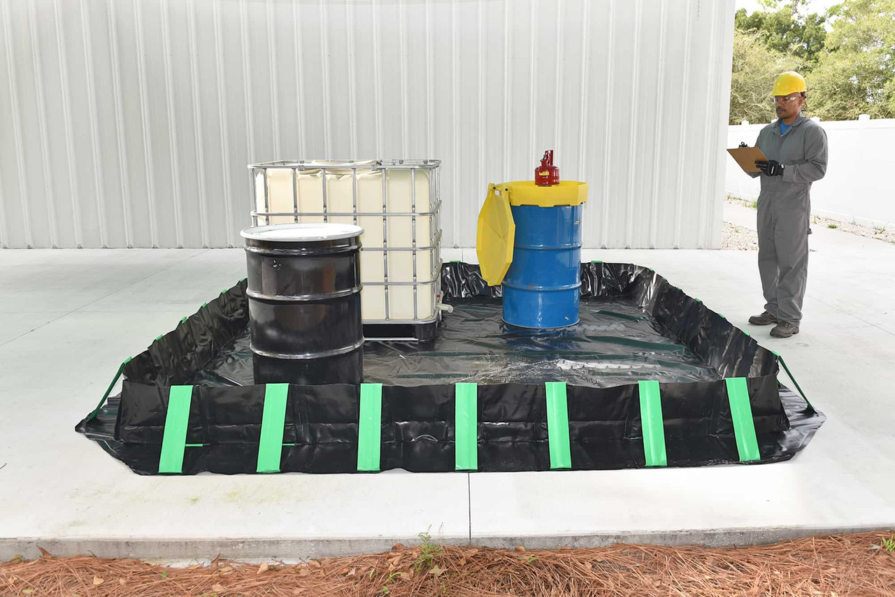 Drums and IBC - Compact containment berm with drums and an IBC, worker inspecting with a clipboard.