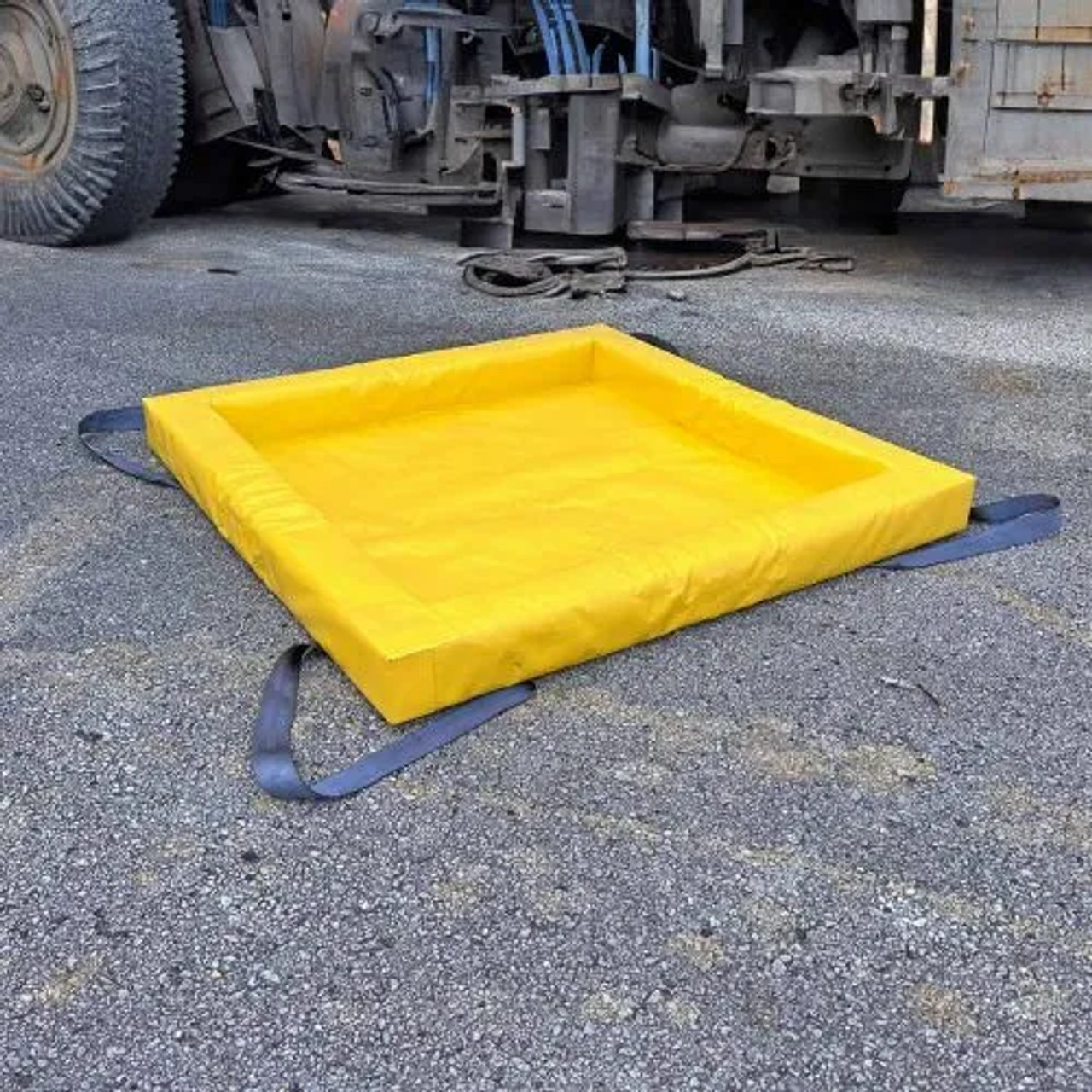 Industrial-grade yellow spill containment tray for outdoor use.