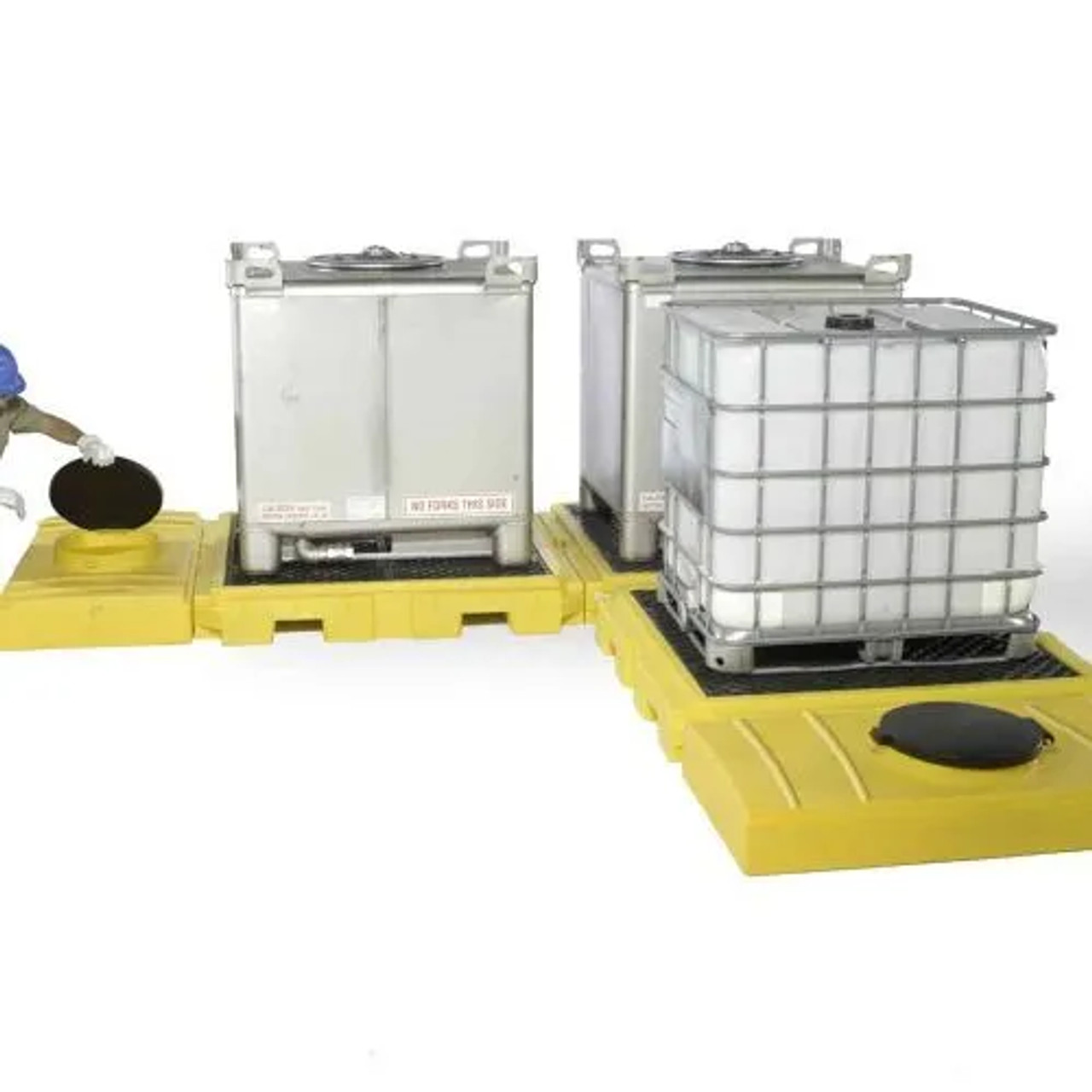 Worker tightening IBC tanks on the spill pallet to ensure secure placement and spill containment.