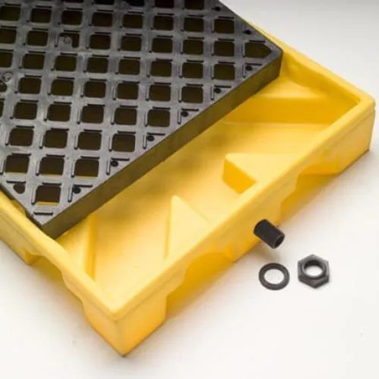 Close-up of Spill Deck P1 with grating removed, highlighting its durable yellow construction and included drain plug.