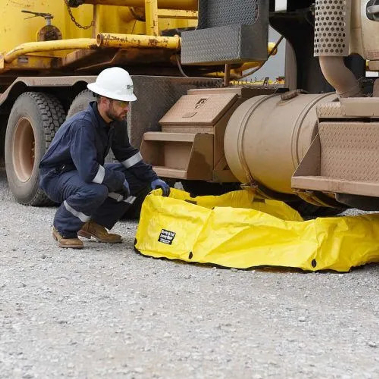 Portable yellow spill containment berm being deployed around industrial equipment for spill protection.