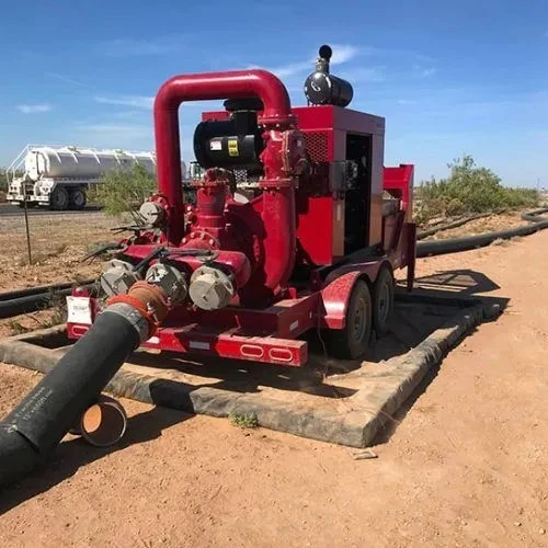 Red pump equipment set up on a foam wall spill containment berm in the field.