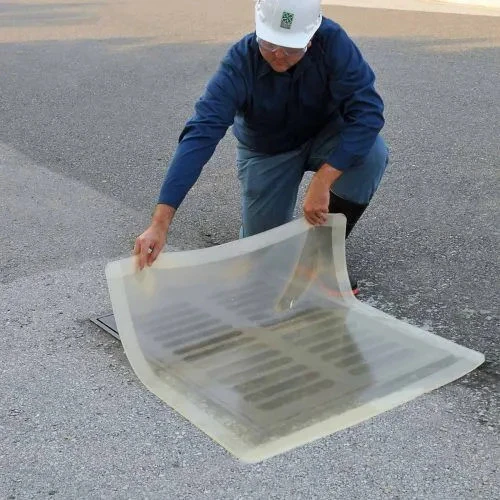 Worker placing a clear 18” x 18” drain seal over a drain, showcasing its flexibility and secure coverage for spill control.