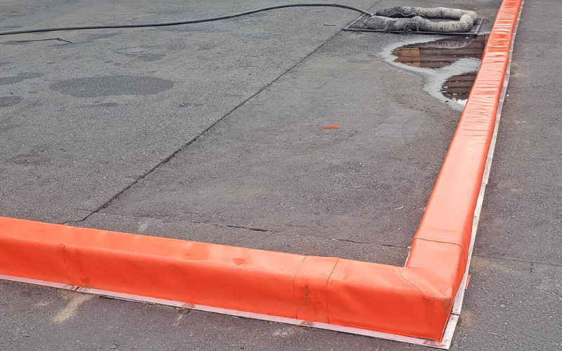 Orange containment berm for modular spill control on asphalt