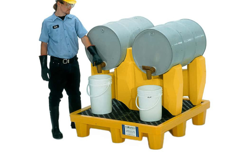 Drum dispensing rack on spill pallet for secondary containment.