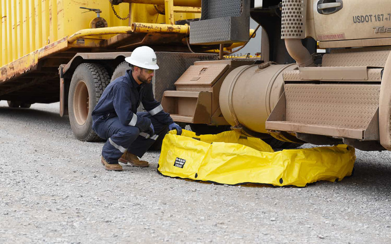Portable spill berm under truck for fuel leak containment.
