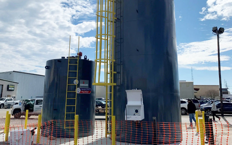 2 green welded steel tank installed in a parking lot