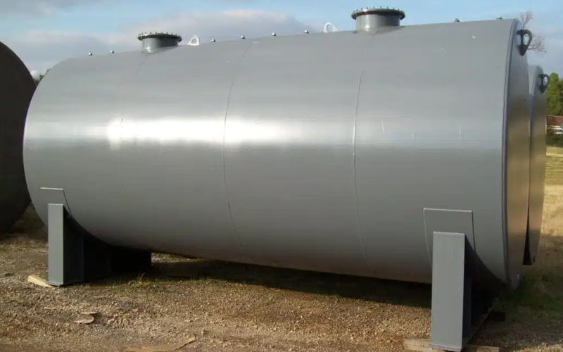 Gray above-ground double-walled fuel storage tank on a gravel surface, designed for secure fuel containment