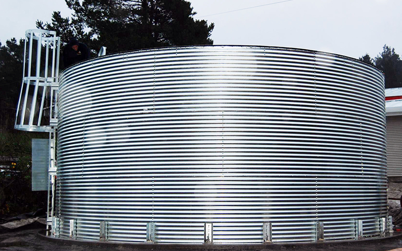 Corrugated metal water tank designed for durable water storage in industrial or agricultural settings, offering high-capacity liquid storage solutions.