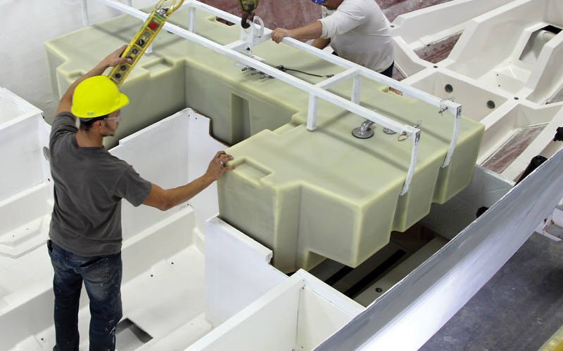 Workers placing a custom tank on a boat