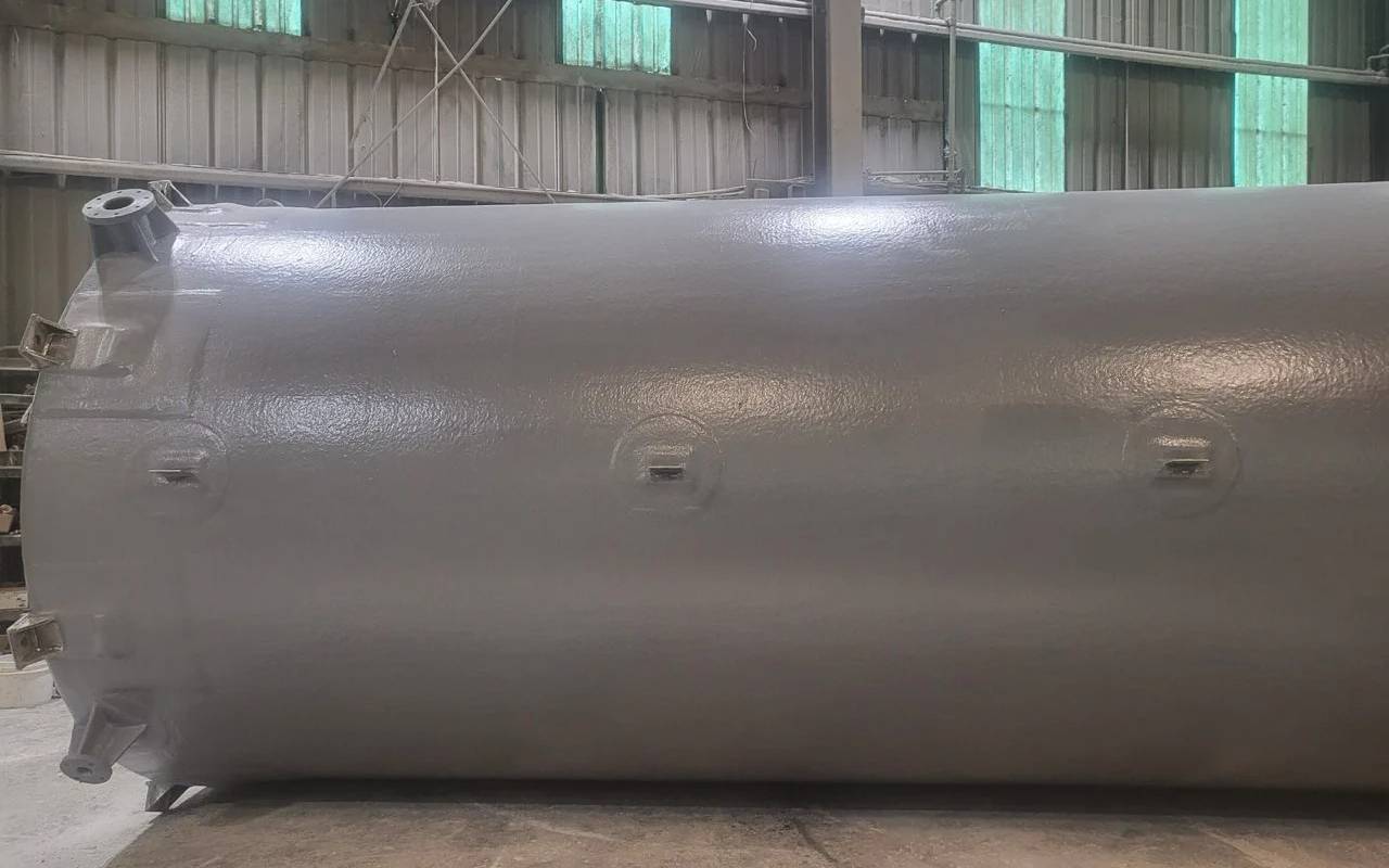 Horizontal fiberglass tank with industrial-grade coating, built for underground water or chemical containment.