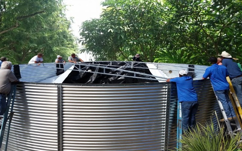 Community members installing a 5000-gallon corrugated steel water tank in the Caribbean.