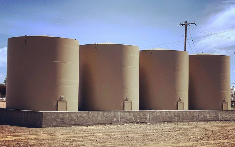 Four large beige fiberglass storage tanks designed for water and chemical storage, offering durable and corrosion-resistant solutions for industrial and commercial applications.