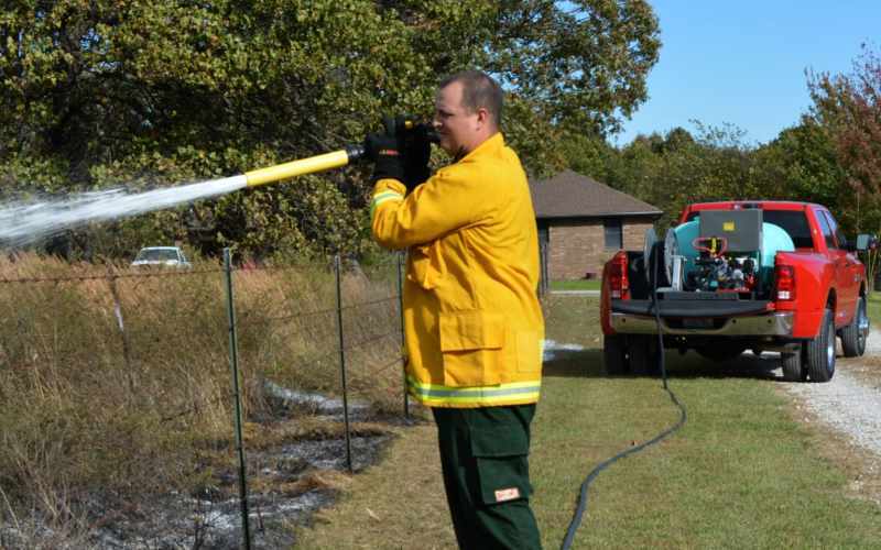 A firefighter using the foam ranger hose to put out a fire