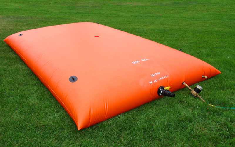 Bright orange pillow tank used for potable water, firefighting reserves, or fuel storage in agriculture and emergency applications.