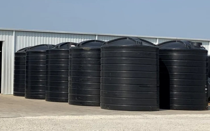 multiple vertical poly tank sitting outside of a facility