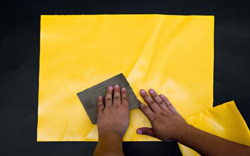 Vinyl repair kit with sandpaper, prepared for tank leak repair, showing the sandpaper for prepping the patch area.